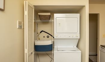 A small laundry room with a washer and dryer at The Brittany Apartments, Maryland